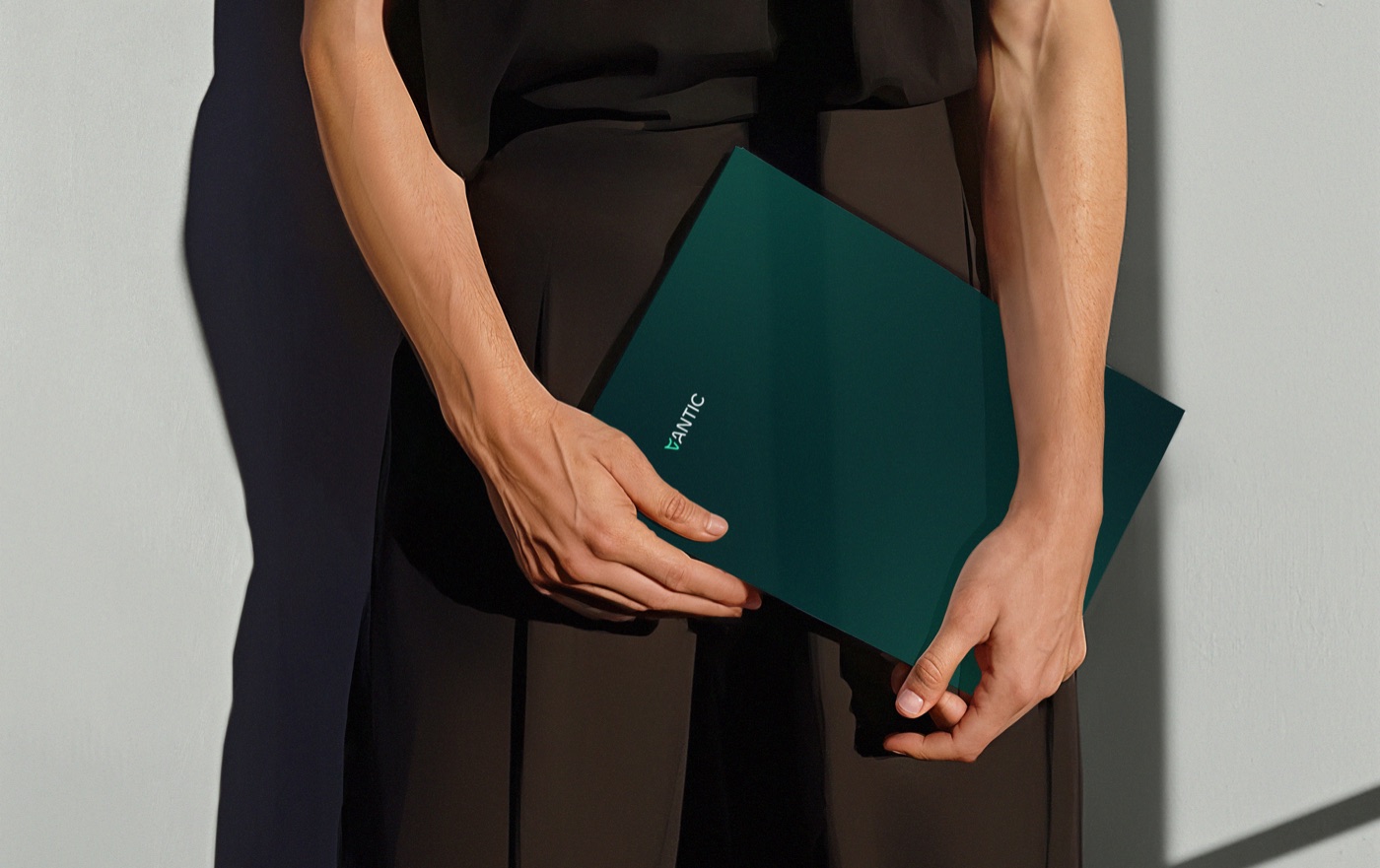 A person holding a deep-teal Vantic presentation folder